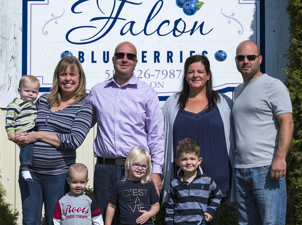 Falcon family standing in front of Falcon Blueberries sign